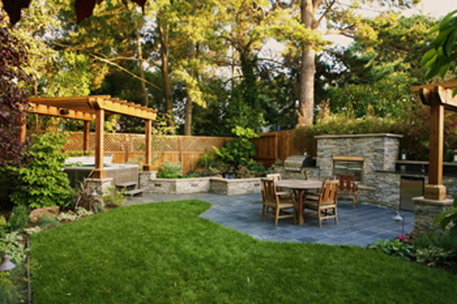 This backyard renovation created an outdoor entertainment area for cooking. The owners also wanted a large stone patio, spa, trellis, lawn area and garden.